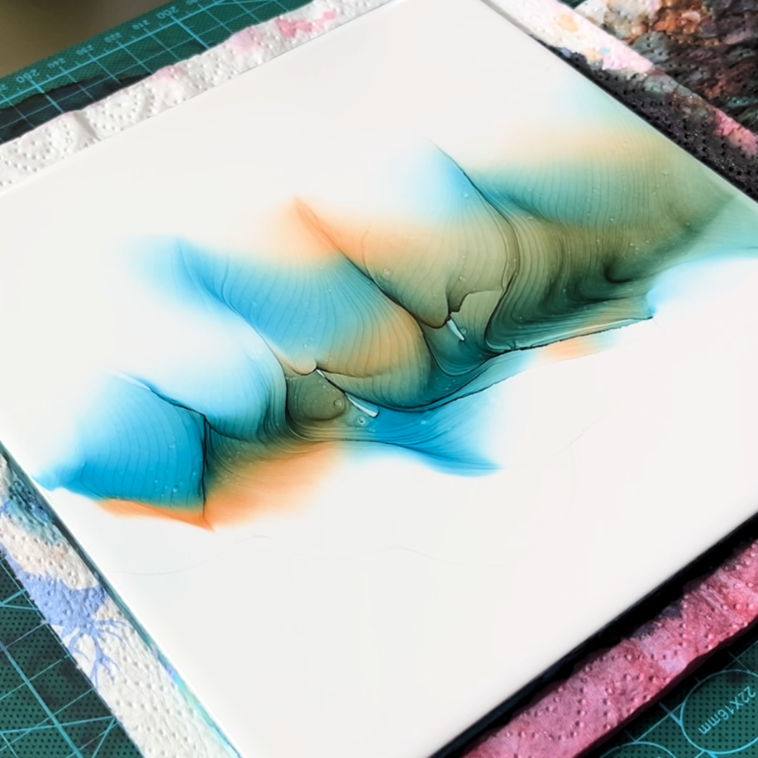Dynamic interplay of vibrant turquoise blue and warm orange alcohol ink currents spreading across smooth synthetic paper by VHacademy
