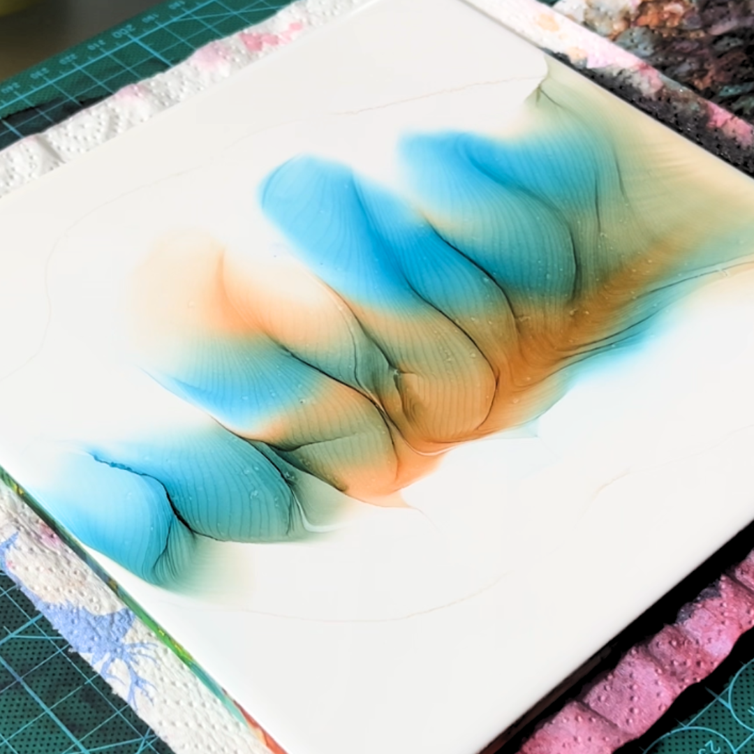 Dynamic interplay of vibrant turquoise blue and warm orange alcohol ink currents spreading across smooth synthetic paper by VHacademy