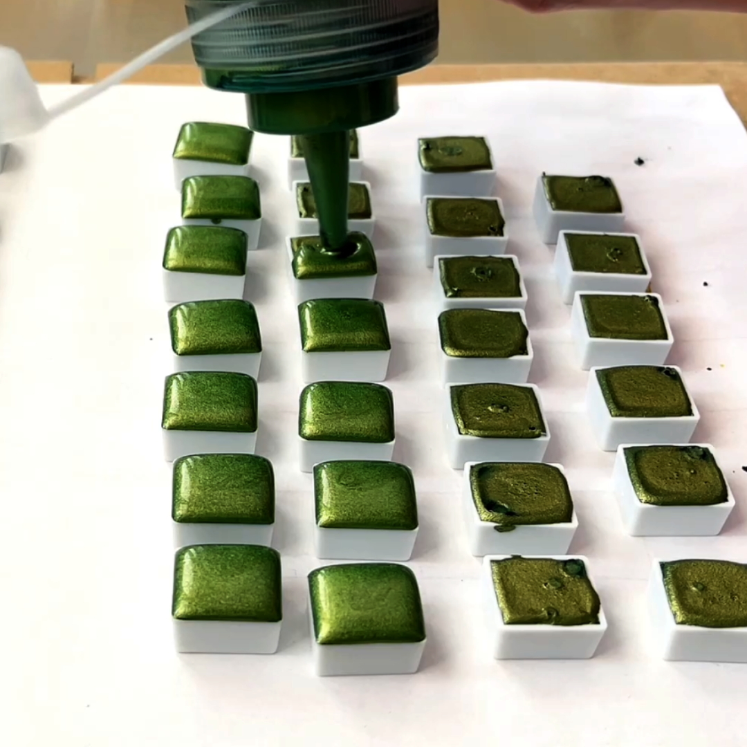 Automated filling of metallic shimmer olive green watercolor into half-pan array by VHacademy