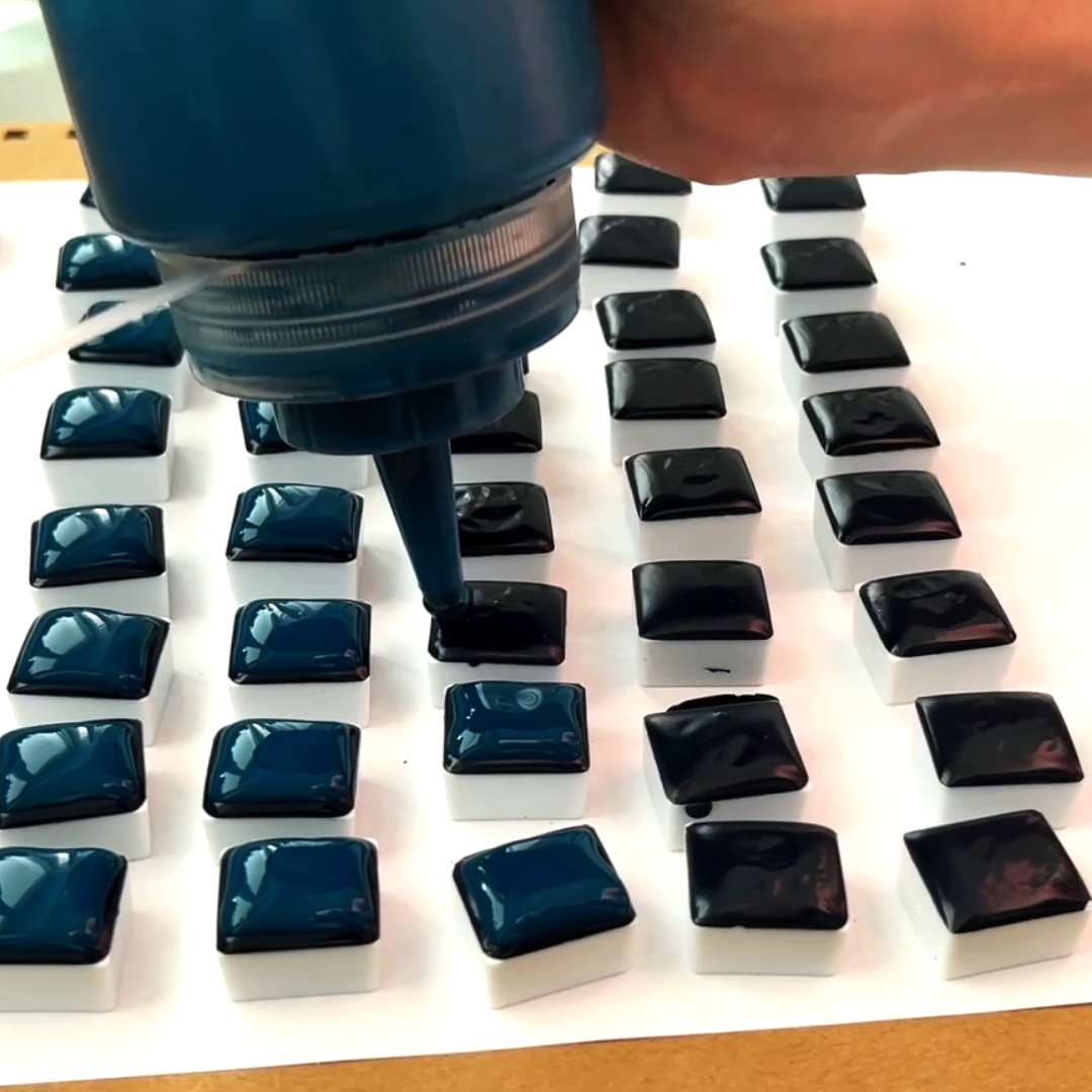 Dispensing glossy midnight blue liquid watercolor pigment into pan molds by VHacademy