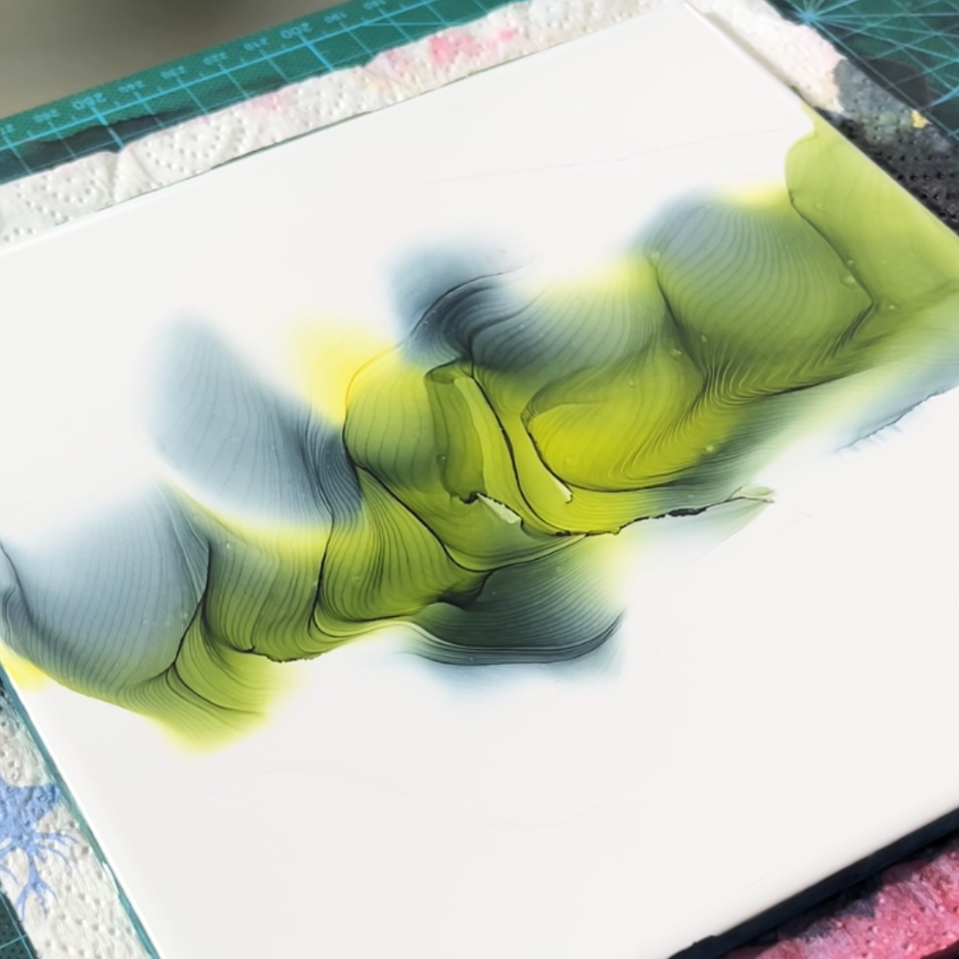 Centrally dispersed yellow and muted dark green alcohol ink showcasing fluid pooling and edge definition by VHacademy
